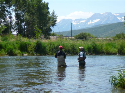 Guide and client playing a fish on the Provo River